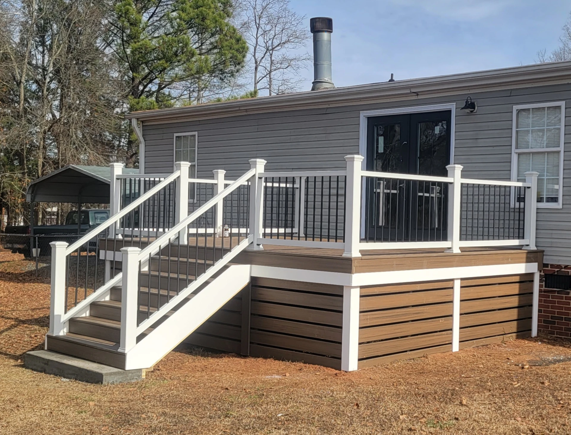 Elevated deck with white railing and black balusters on the wooden deck
