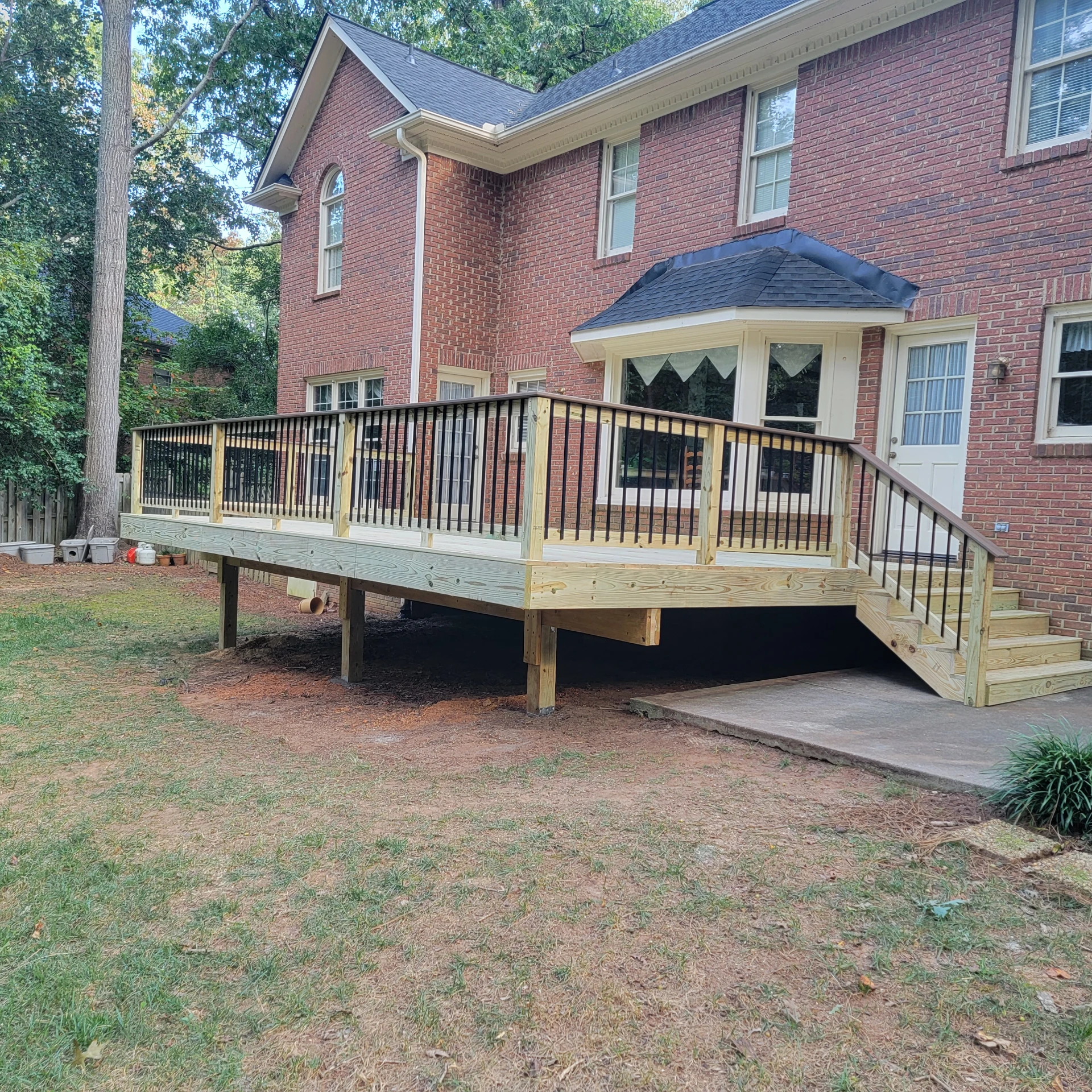 Elevated wooden deck attached to brick house
