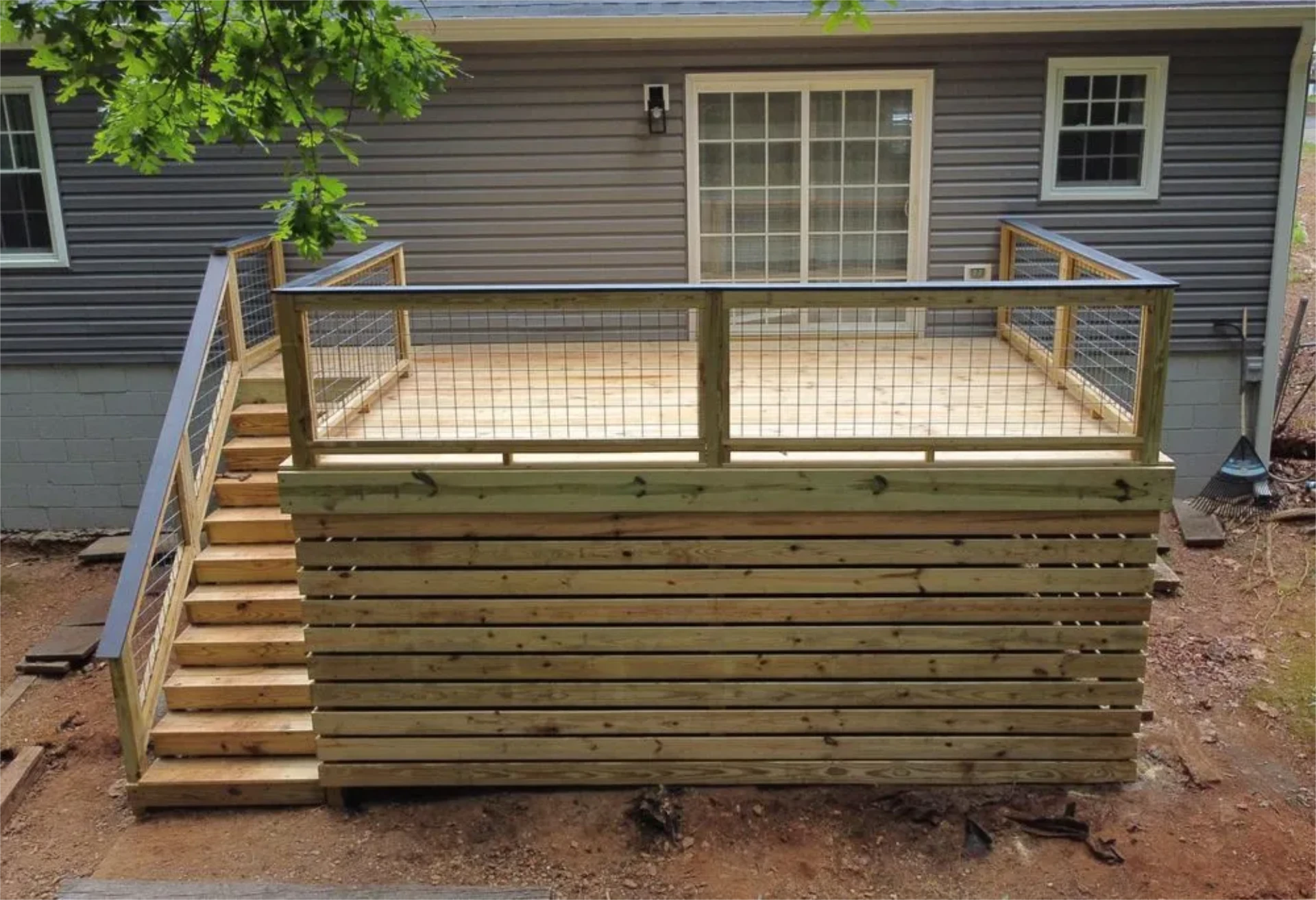 Elevated wooden deck with wooden stairs and wire railing
