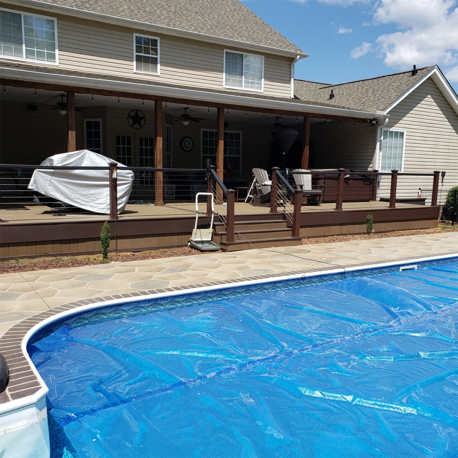 Finished poolside deck with cable railing and steps.