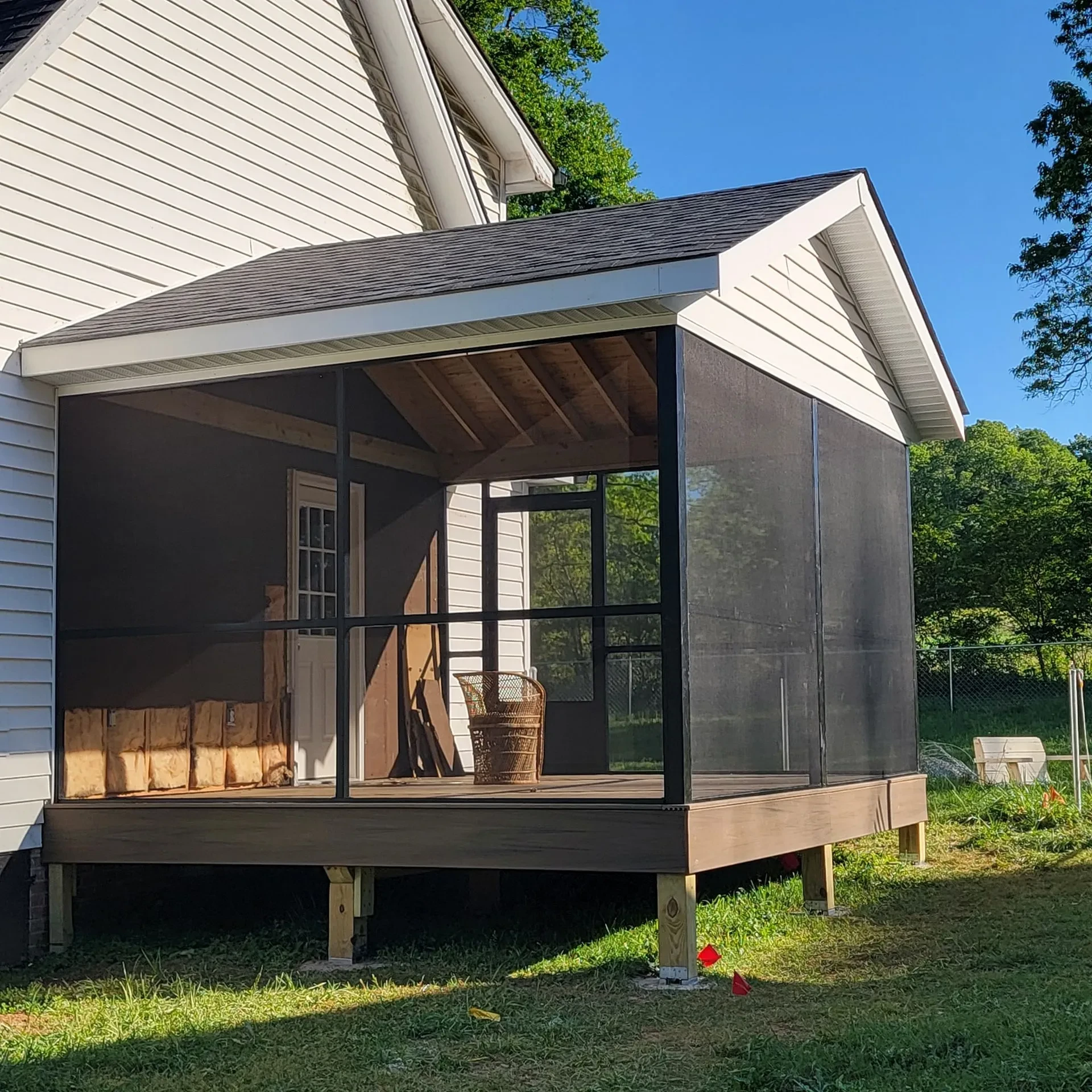 Screened porch addition with gable roof on the brown deck