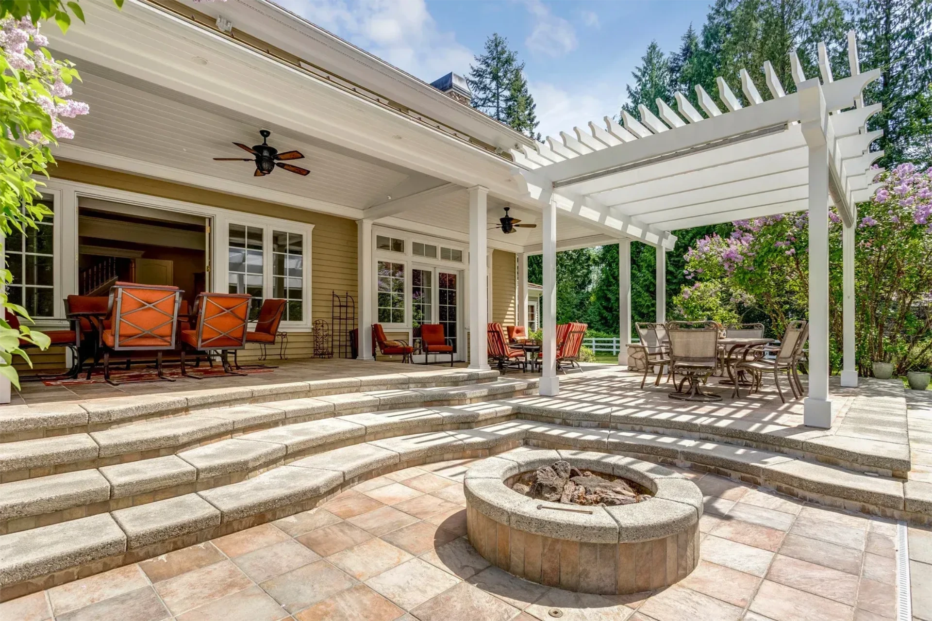 Covered patio seating with white pergola and fire pit