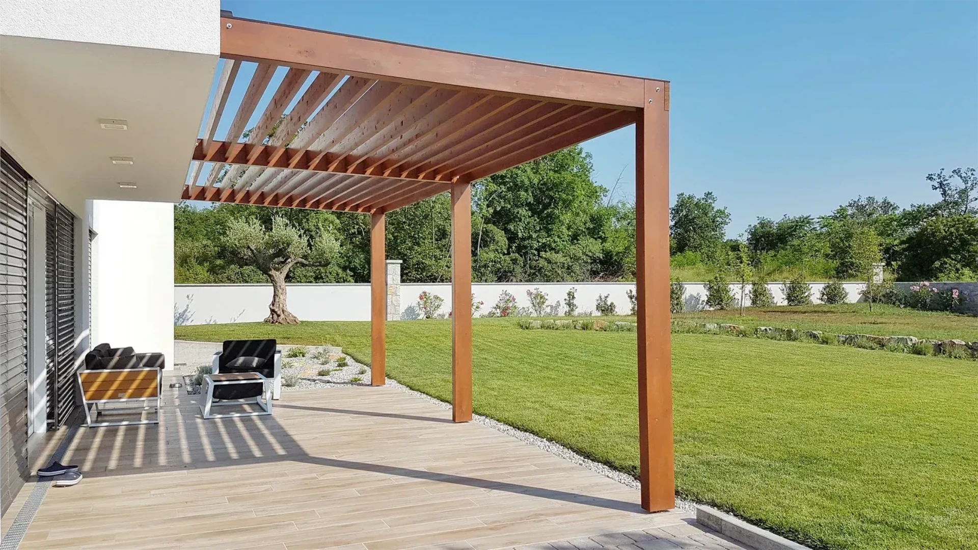 Medium size wooden pergola over backyard patio beside lawn