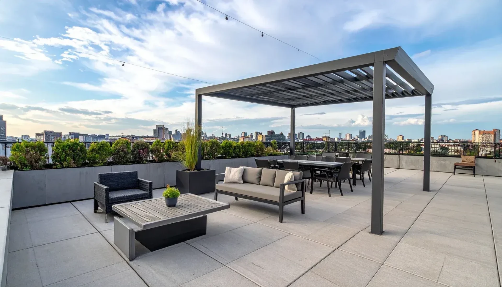 Rooftop terrace with modern pergola and city skyline and patio seating