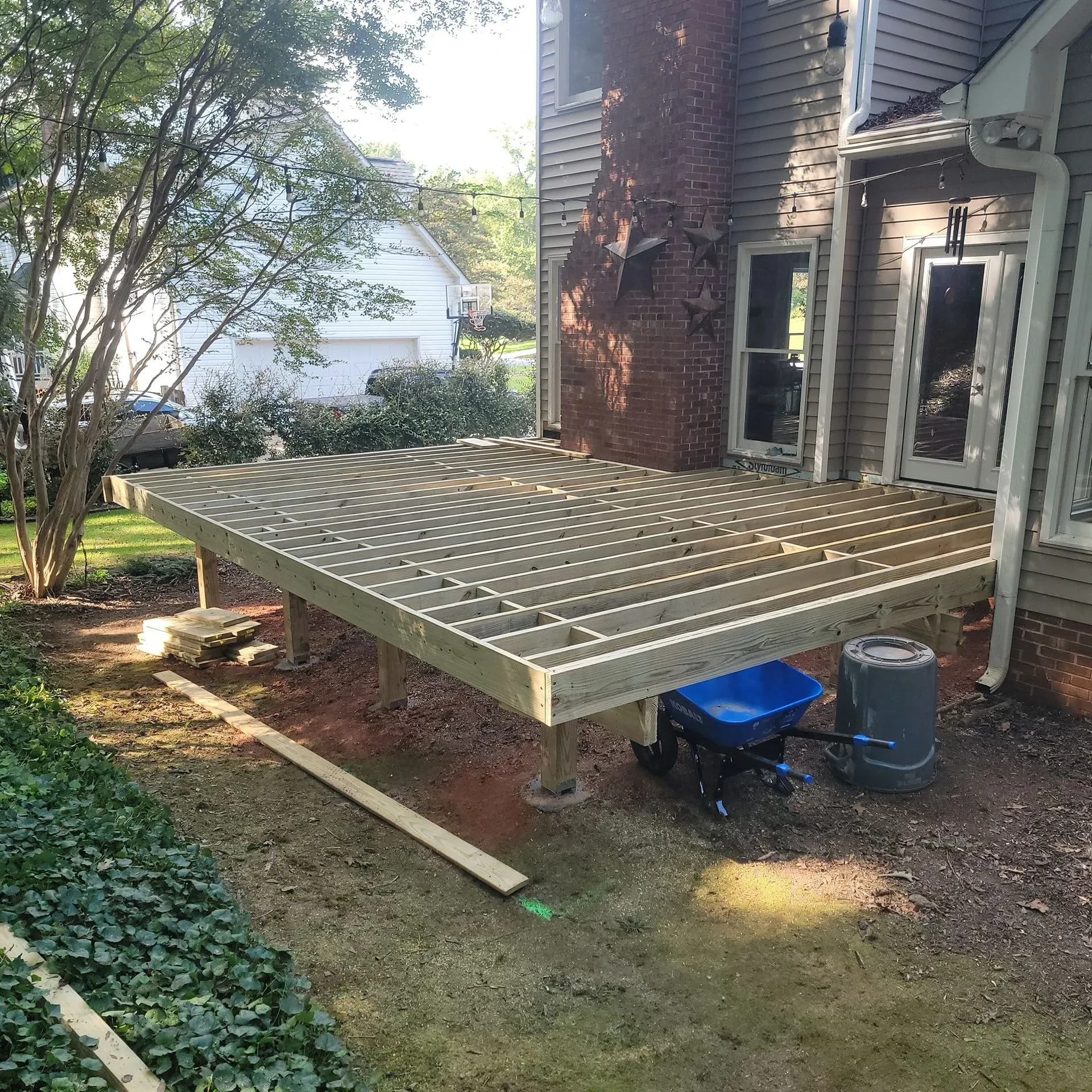 Wooden deck frame under construction beside the house windows